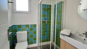 Un baño con inodoro, ducha y lavamanos.