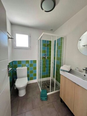 Une salle de bain avec des toilettes, une douche et un lavabo.