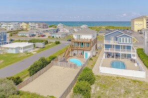 A coastal residential area with a large house featuring a pool and a second-story balcony. - JLJR #107 Memory Maker, Semi-Oceanfront, 1 min walk to beach, Pool Hot Tub Pets (Nags Head)