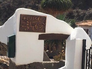Une enseigne portant l’inscription « EL LAGAR DE TUNTE », fixée sur une structure blanche et agrémentée d’un portail en métal.