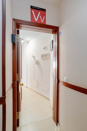 A hotel entrance with a wooden door, a sign above indicating 'VIVIENDA VACACIONAL,' and a tiled floor. - Welcome (Puerto del Rosario)
