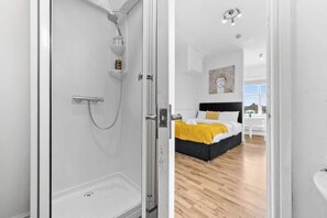 A modern bathroom with a glass shower enclosure and a visible toilet. - Gorgeous studio near Leeds City Centre - Room 5 (Leeds)