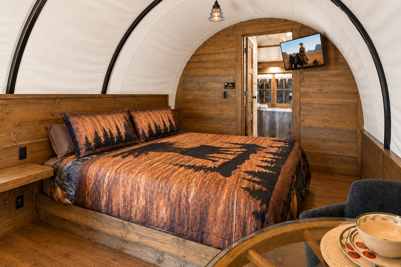 A cozy interior with a bed, seating area, and a dining table.