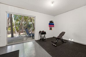 A gym with a bench, dumbbells, and yoga mats. - Heated Pool • Home Gym • Walk to Beach (Holmes Beach)