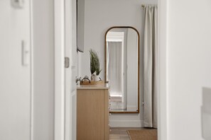 A hallway with a wooden vanity, a mirror, and a potted plant. - Heated Pool • Home Gym • Walk to Beach (Holmes Beach)