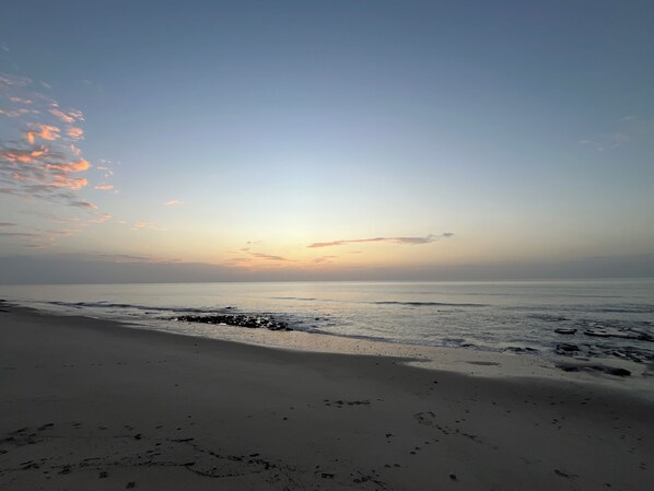 A beach with a calm sea and a clear sky.
