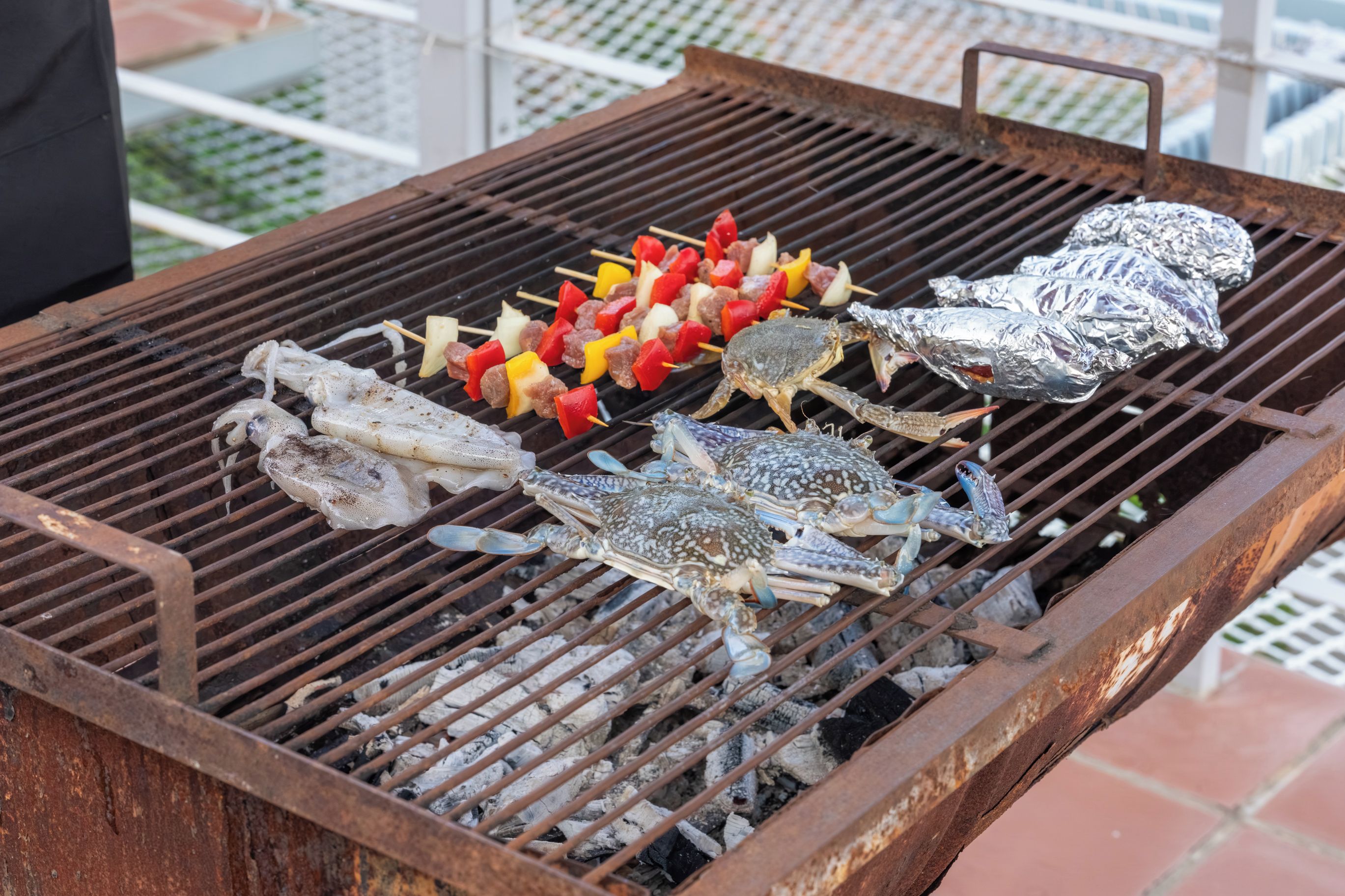 A grill with seafood and skewers.