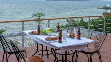 A table set for dining with a view of the sea and distant mountains.