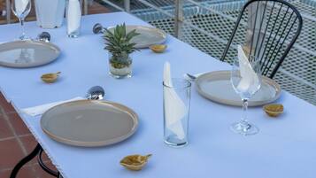 A table set for dining with plates, glasses, and a small plant.