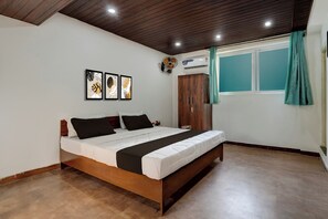 Ein Schlafzimmer mit einem Bett, einem Kleiderschrank, einem Fenster mit Vorhängen und Wandbildern.