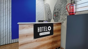 A hotel reception desk with a sign indicating it is company-serviced. - Hotel O Kodgehalli Railway Station (Bangalore)