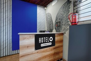 Ein Hotel-Rezeptionstresen mit einem Schild, das anzeigt, dass er vom Unternehmen verwaltet wird.