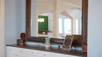 A mirror with a wooden frame, a small chalkboard sign, and decorative items on a dresser.