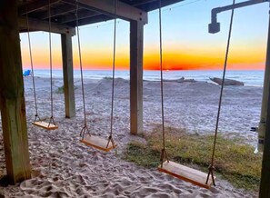 A beach view with a wooden swing set and a covered area with a view of the sunset. - Steps to the Sand - 14 Beds - Sleeps 19 + Hot Tub (Surfside Beach)