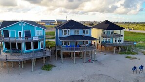 Ein strandnahes Anwesen mit mehreren Häusern, jedes mit einem Balkon und einer kleinen Terrasse.