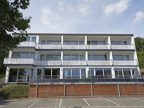 A multi-story building with balconies and a parking area in front. - Holiday Apartment 603 (Winterberg)