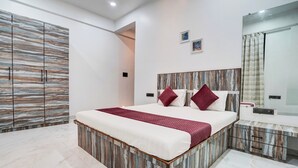 Quarto moderno com uma cama grande, um guarda-roupa, um espelho e uma mesa de cabeceira.
