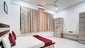 Quarto moderno com cama, ventoinha no teto, ar condicionado e guarda-roupa.
