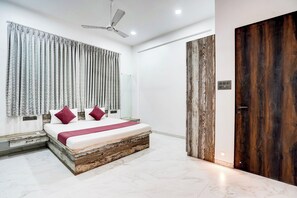 Une chambre moderne avec un lit, des rideaux, un ventilateur de plafond et une porte en bois.