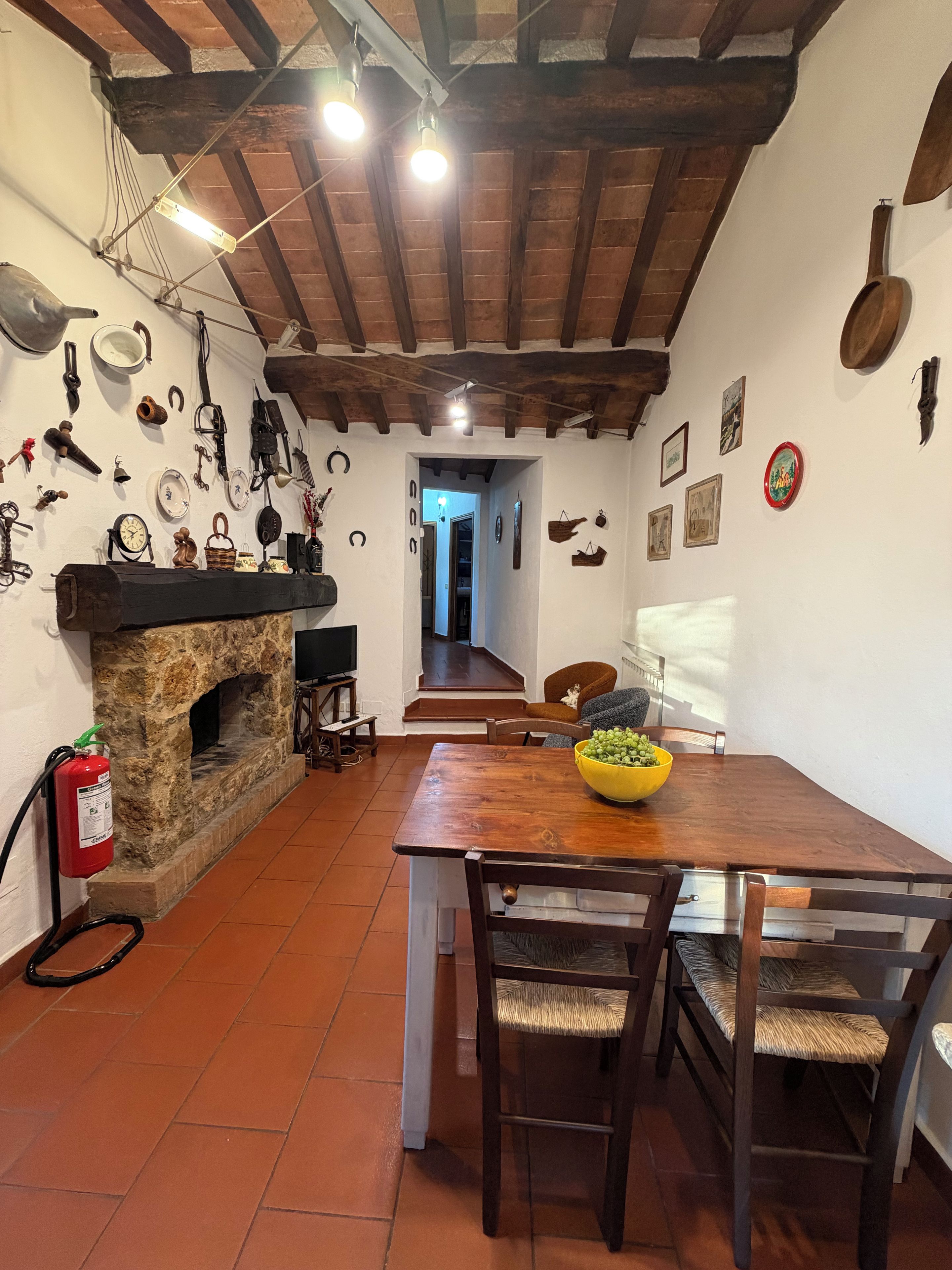 Ein rustikales Interieur mit einem Steincheminée, Holzbalken und verschiedenen Wanddekorationen.