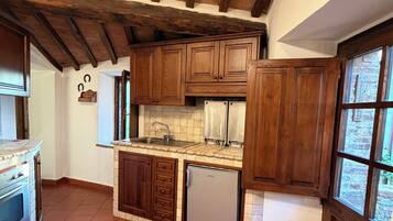 Une cuisine avec des meubles de rangement en bois, un four encastré et un réfrigérateur.