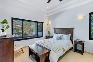 A bedroom with a bed, bedside tables, a desk, a chair, and a window with blinds. - Beautiful 4-bedroom house with AC and private pool in Brasilito Beach (Brasilito)