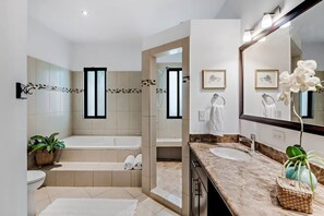 A modern bathroom with a bathtub, toilet, and sink. - Beautiful 4-bedroom house with AC and private pool in Brasilito Beach (Brasilito)