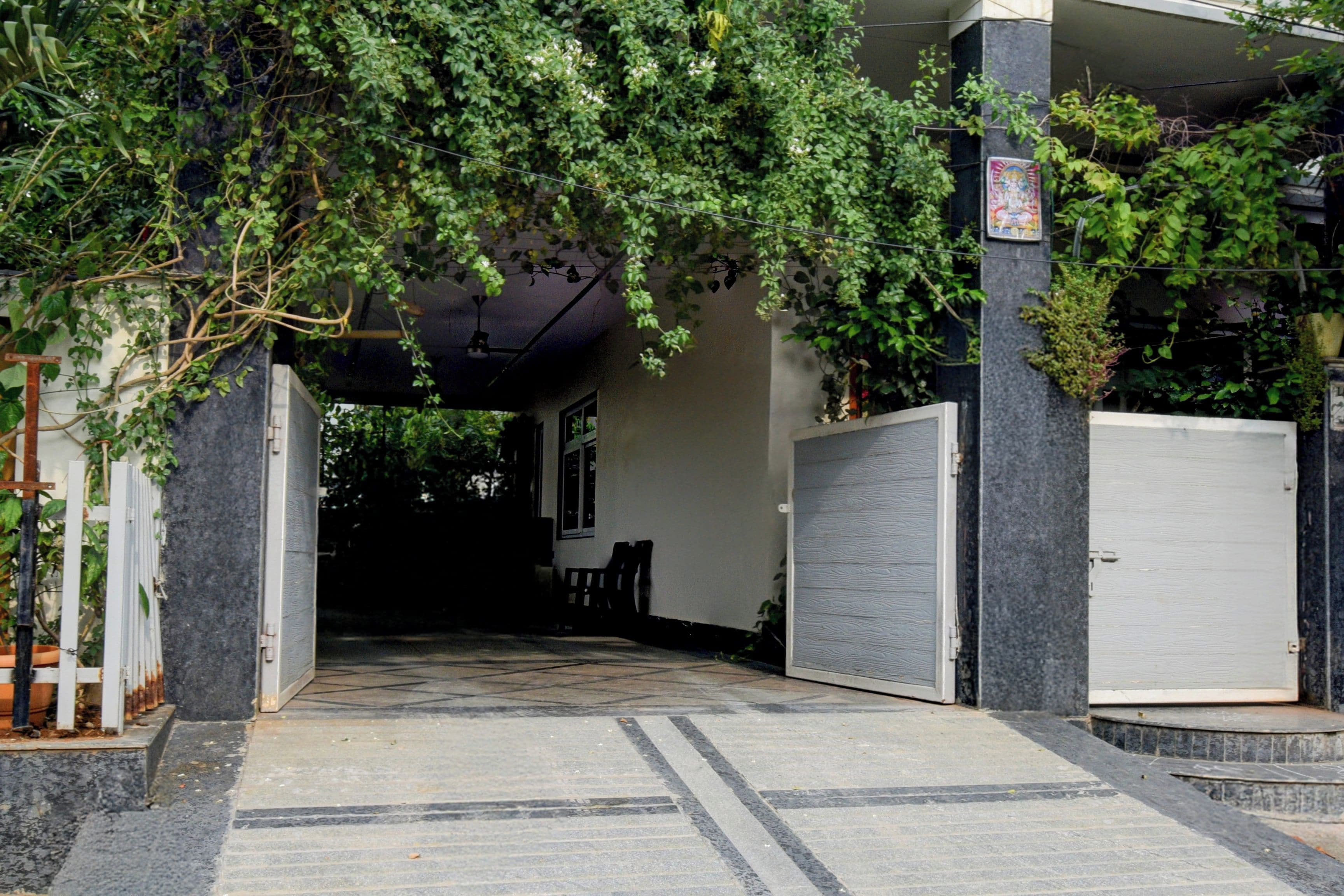 A pathway leading to a building entrance with a tiled floor and a door on the right.