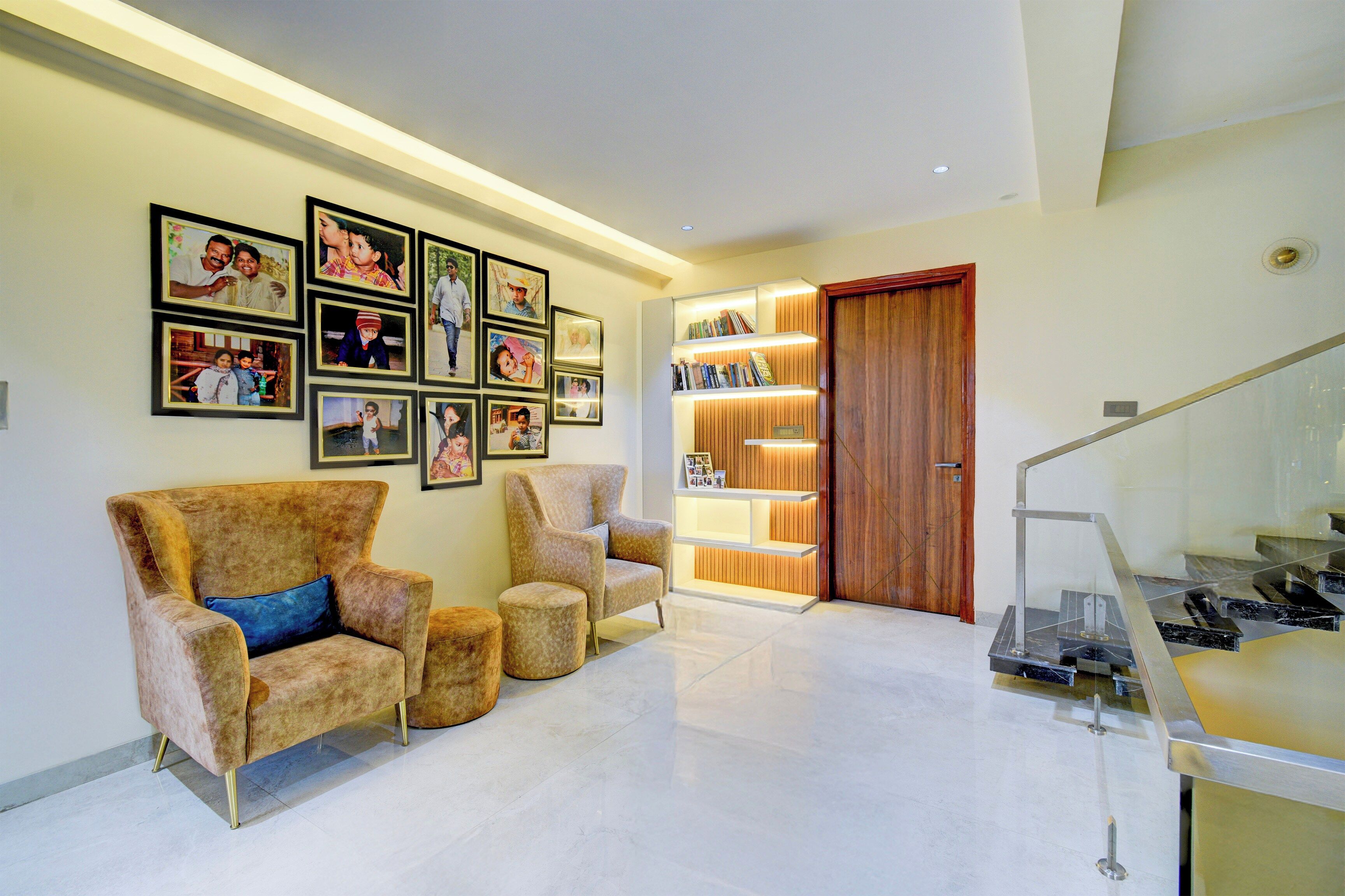 A modern interior with a seating area, a wooden door, and a staircase.