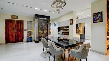 A modern kitchen with a black countertop, white cabinets, and a stainless steel refrigerator.