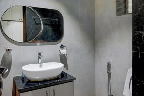 Un bagno con lavandino bianco, specchio, toilette e doccia.