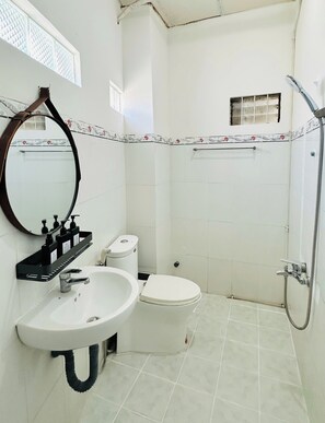 A bathroom with a sink, toilet, and shower.