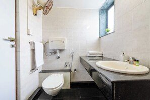 A compact bathroom with a toilet, bidet, and sink. - DanCenter Trizi Villa 4BHK with Pvt Pool (Lonavala)