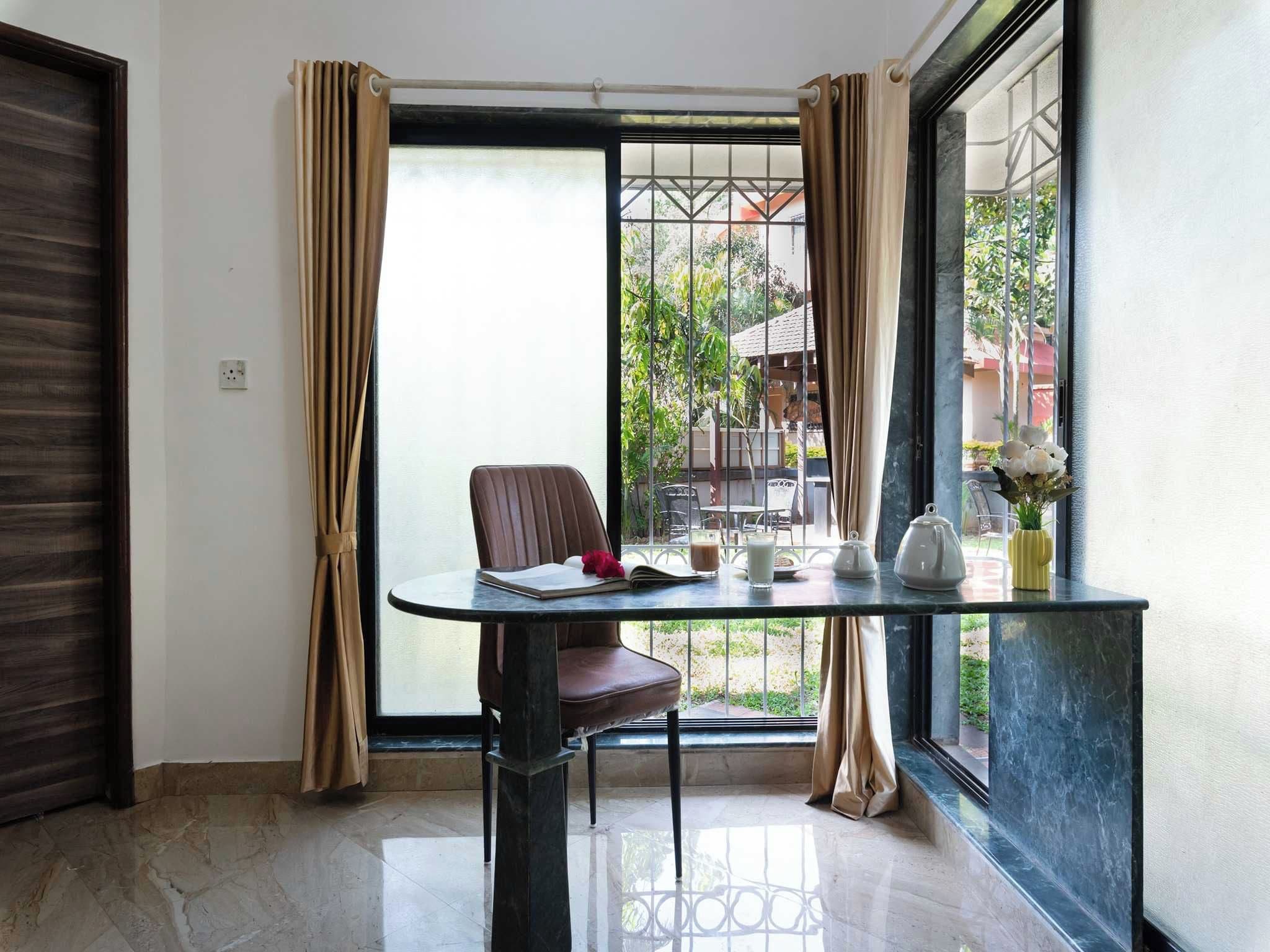 A corner room with a table, chair, and a view of the outside.