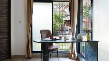 A corner room with a table, chair, and a view of the outside.