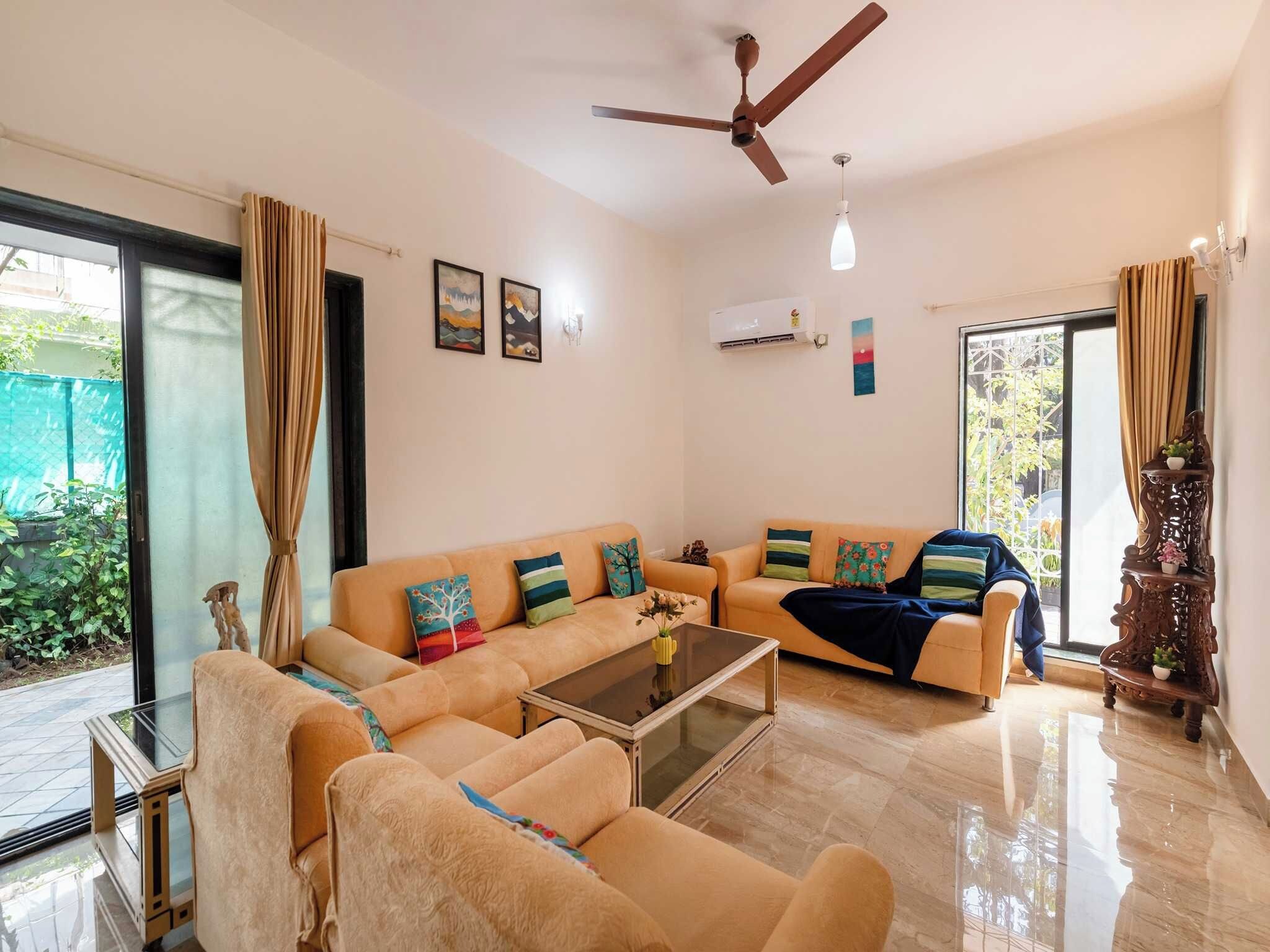 A modern living room with a sofa set, a coffee table, and a ceiling fan.