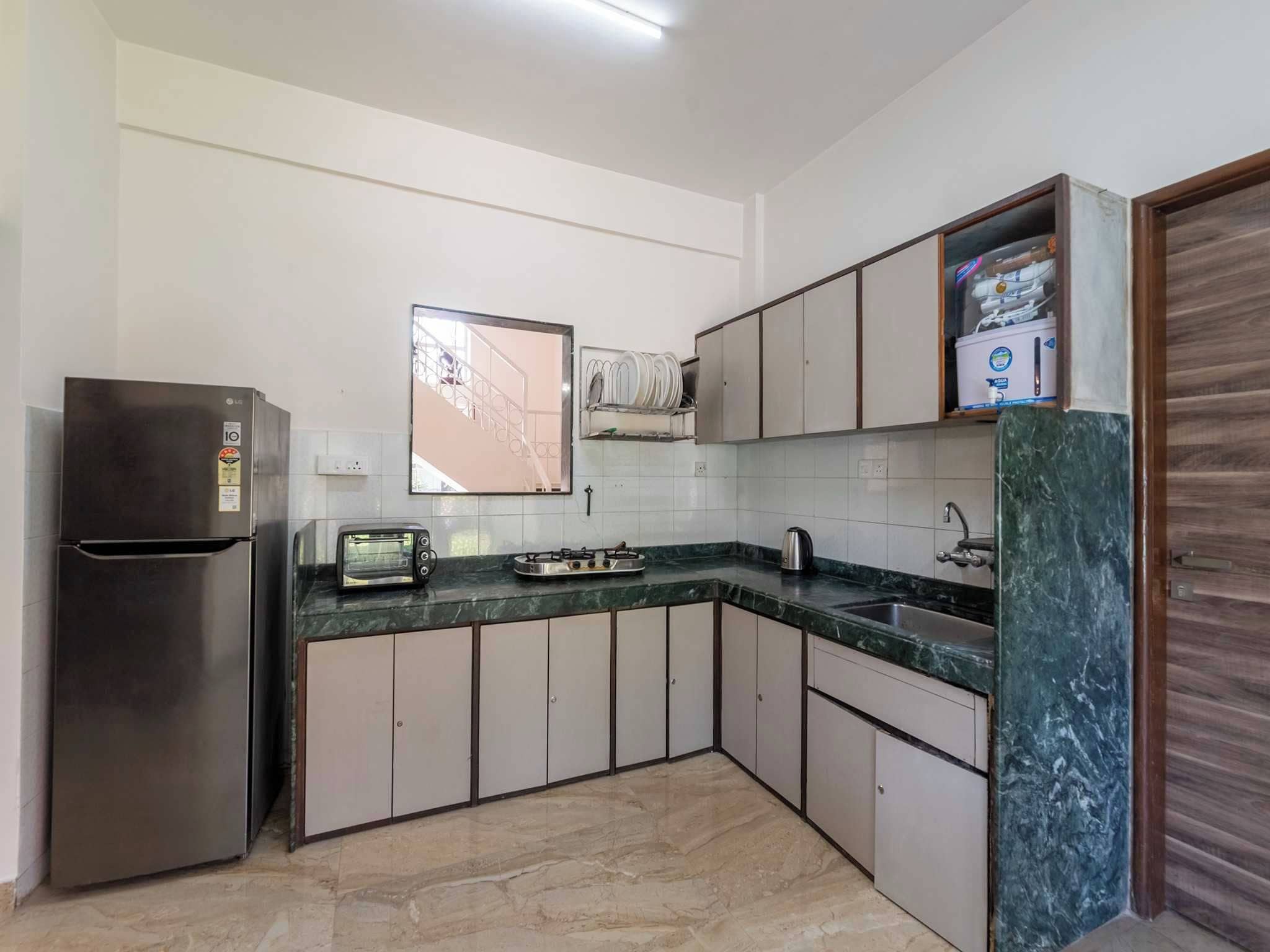 A kitchen with a refrigerator, a stove, a sink, and cabinets.