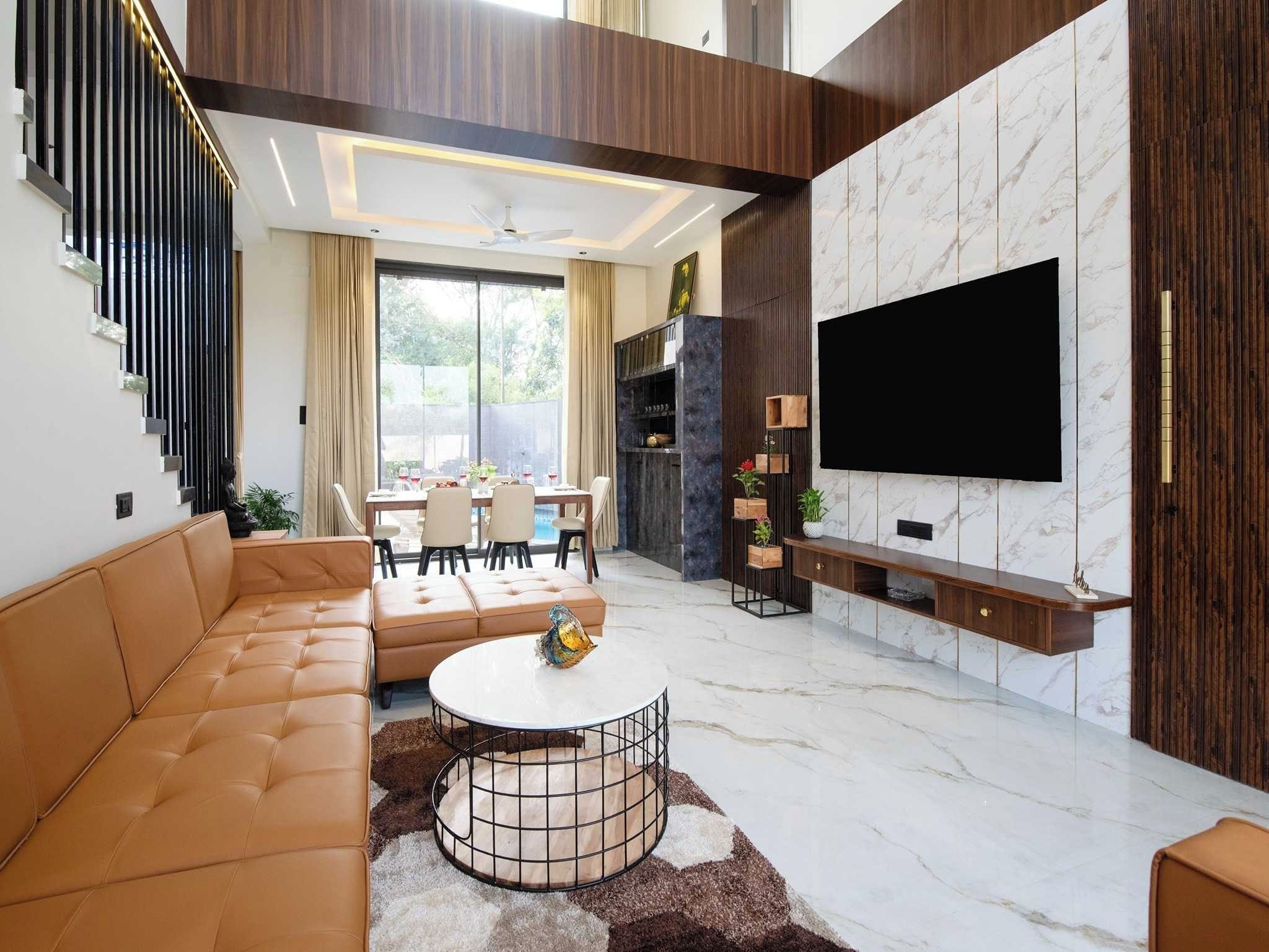 A modern living room with a sofa, coffee table, and a flat-screen TV mounted on the wall.