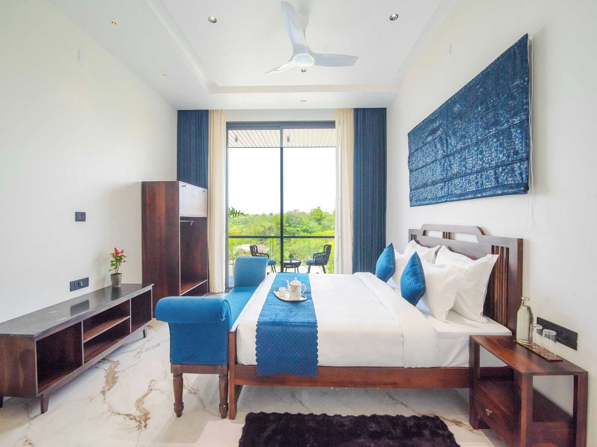 A modern bedroom with a bed, bedside tables, a desk, and a chair.