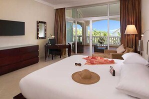 Une chambre d’hôtel avec un grand lit, un bureau, une chaise, une télévision et un balcon avec vue.