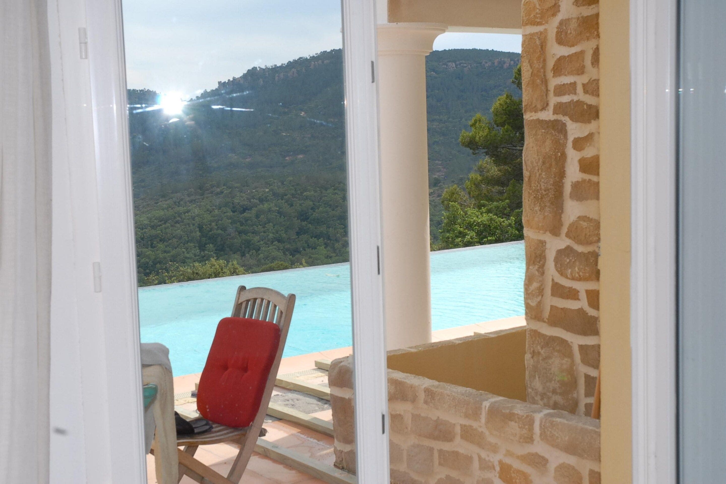 A room with a view of a mountain and a pool.