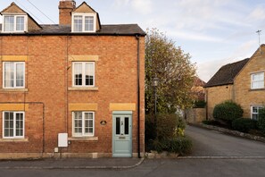 A two-story brick building with a traditional design, featuring multiple windows and a front door. - Charming Cotswold Escape - Moreton in Marsh - Dog friendly (Moreton-in-Marsh)