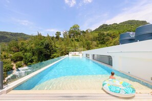 A swimming pool with clear water, surrounded by lush greenery and hills. - Kamala - Nature View from Above (Tambon Kamala)