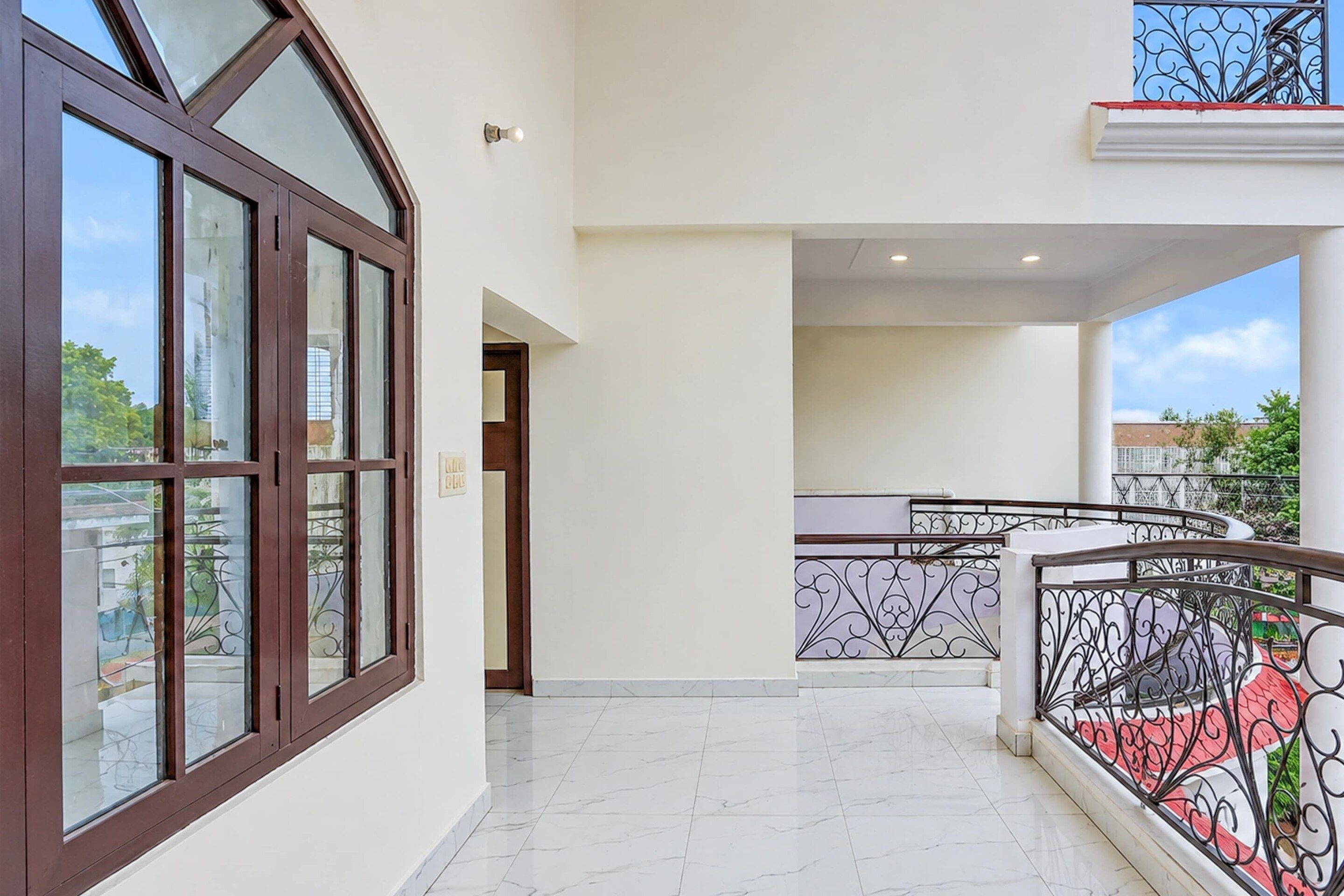 Un edificio residencial moderno con balcón, escalera y vistas del entorno.