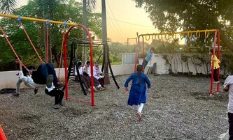 A playground with swings and a climbing structure.