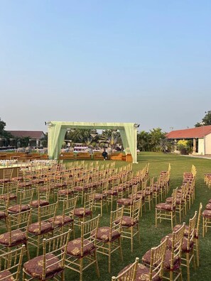 An outdoor event space with rows of chairs and a stage.