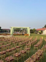 An outdoor event space with rows of chairs and a stage.