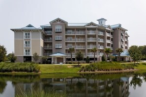 A multi-story hotel with balconies, a swimming pool, and a landscaped garden. - Cozy 2-bedroom apartment in beautiful Hilton Head Island with AC (Hilton Head Island)