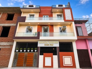 A two-story building with a sign reading 'Mangal Bhawan Home Stay'.