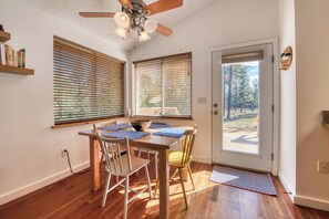 Ein Essbereich mit Holztisch, Stühlen und Deckenventilator.